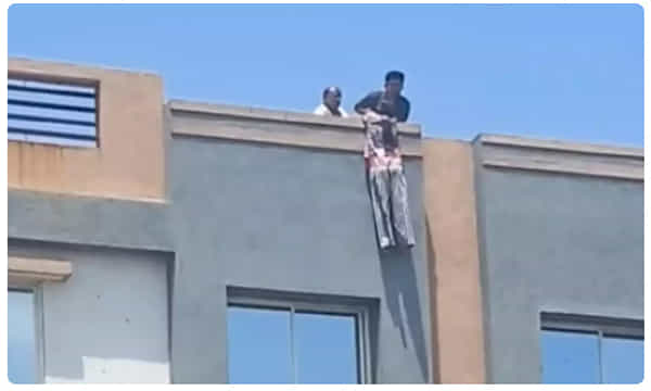 నాలుగంతస్తుల భవనంపై వేలాడిన యువతి.. గట్టిగా అరవడంతో..