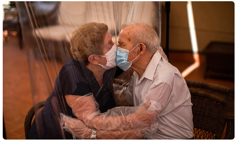 కరోనా విడదీసిన వృద్ధ దంపతులను ప్లాస్టిక్ షీట్ కలిపింది..!