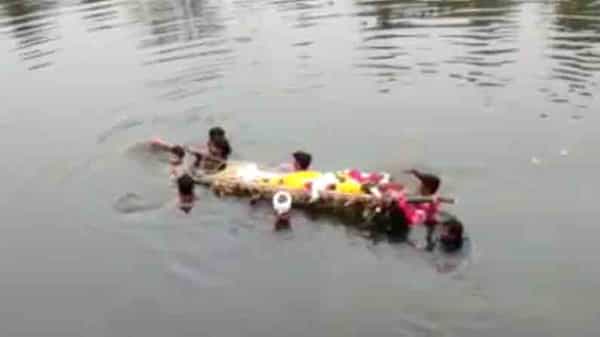 నదిలో ఈదుకుంటూ వెళ్లి అంతిమక్రియలు.. శ్మశానవాటిక లేక గ్రామస్థులకు తప్పని తిప్పలు