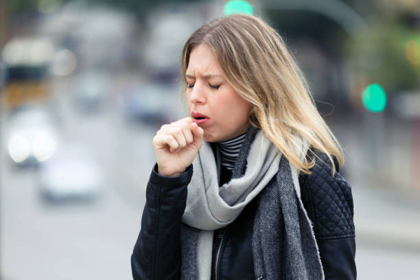 Shot Of Illness Young Woman Coughing In The Street.