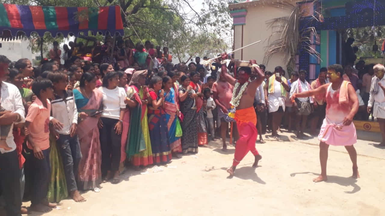 వీరభద్ర స్వామి ఆలయ పూజారి రూపంలో గుడిలో ఉన్న త్రిషులం ను తీసుకొని తల్లిదండ్రుల ఉత్సవ విగ్రహాలను నెత్తిమీద ఉంచుకొని ఆగ్రహం తో నాట్యం చేస్తు భక్తులను తన కాళితో తన్నినట్లు ఆలయ చరిత్ర చెబుతోంది అలా స్వామి వారి కాలి తన్నులు తిన్న వారికి మోక్షం జరిగిందని భక్తులు అంటున్నారు. దాదాపు 500 ఏళ్ల నాటి కి ముందు నుంచి వస్తున్న ఈ ఆచార సంప్రదాయం భక్తి క్రీడను తాము ఇప్పటికి కొనసాగిస్తున్నామని చెబుతున్నారు