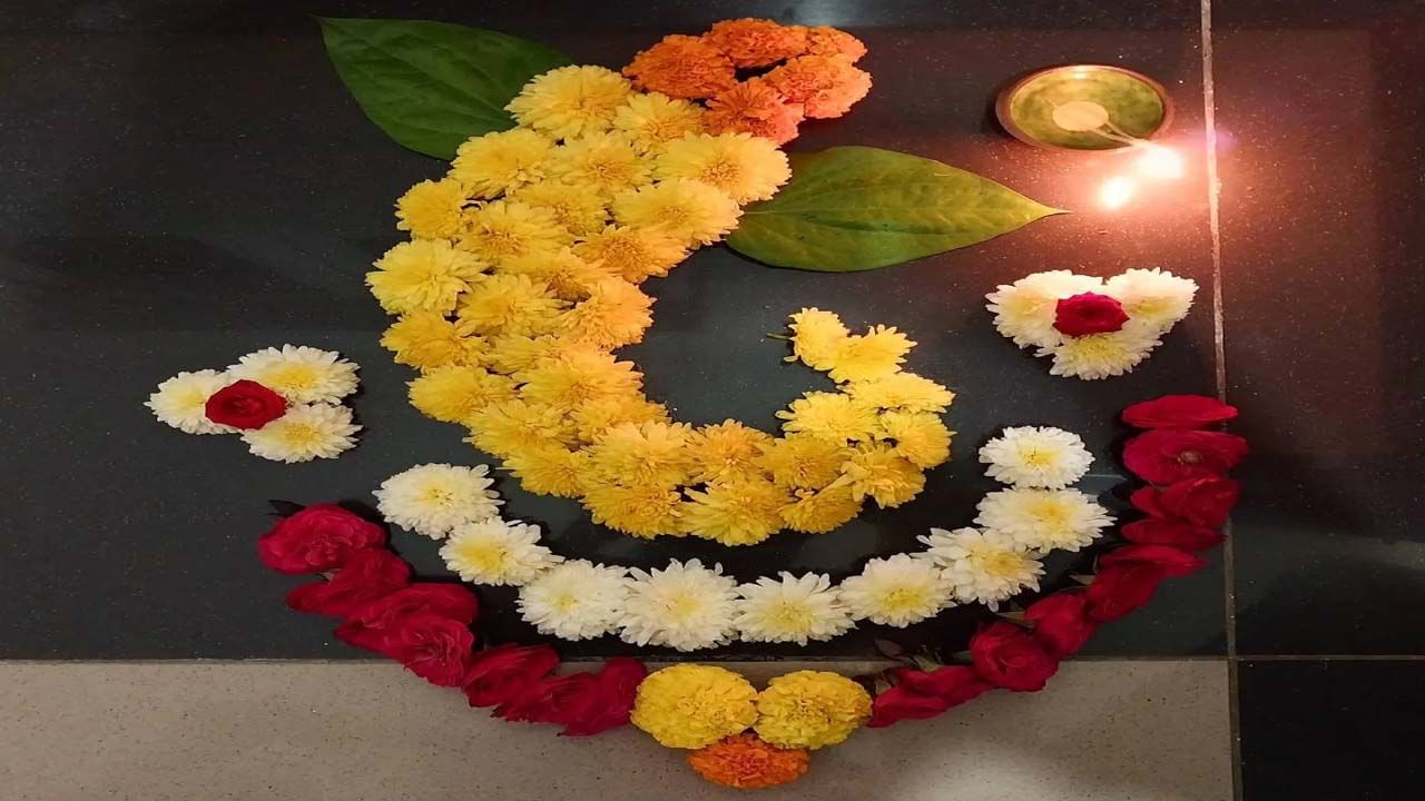బంతి పువ్వు, గులాబీ, తెలుపు రంగు చామంతి పువ్వులను ఉపయోగించి గణేశుడి బొమ్మను తయారు చేశారు. తమలపాకులను కూడా ఉపయోగించారు. పూలతో చేసిన ఈ రంగోలి డిజైన్ చాలా ముద్దుగా కనిపిస్తుంది. మీరు కూడా దీన్ని సులభంగా కాపీ చేయవచ్చు.