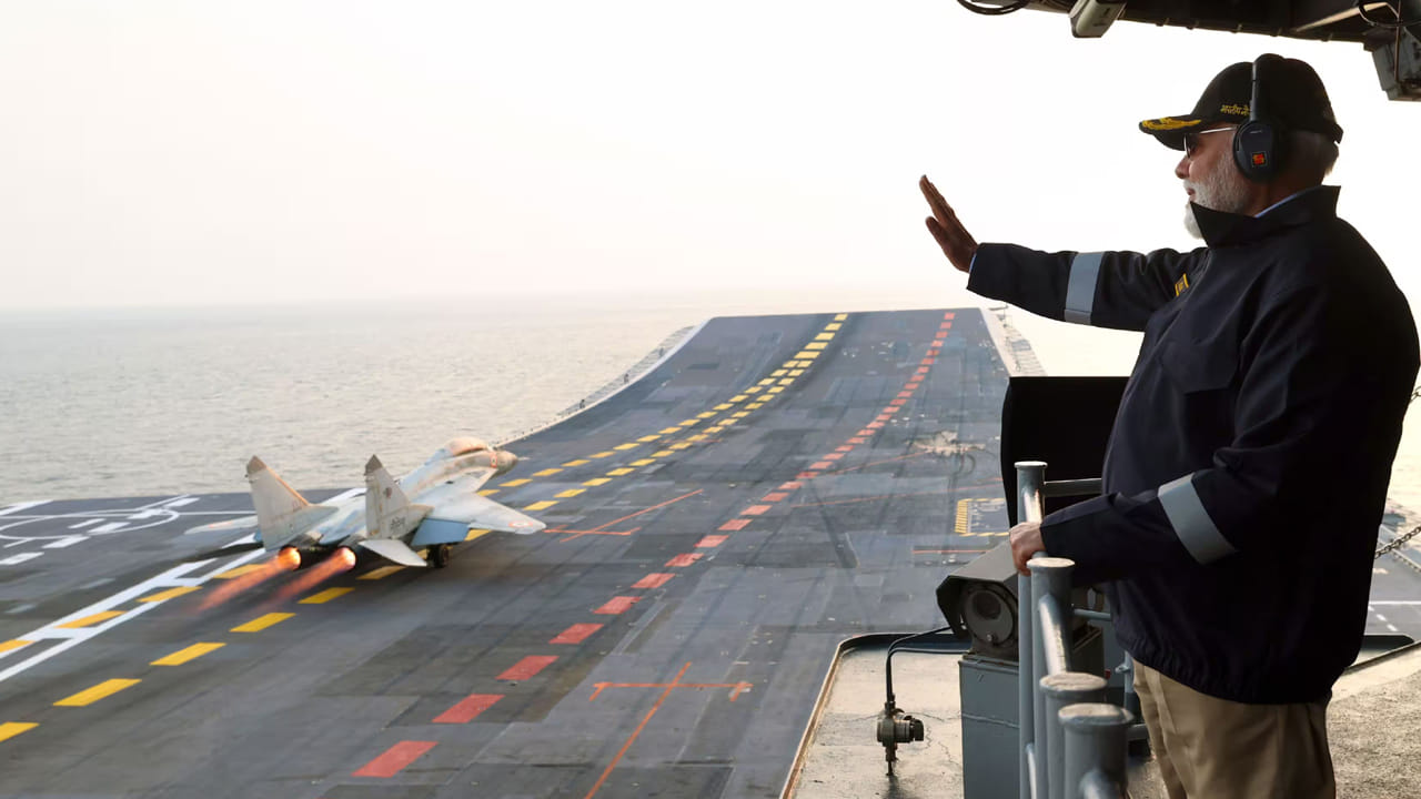 గోవాలో ఐఎన్ఎస్ విక్రాంత్‌లో అద్భుతమైన ఎయిర్ పవర్ డెమోను వీక్షిస్తూ ప్రధాని మోదీ చేయి ఊపుతున్నారు.

