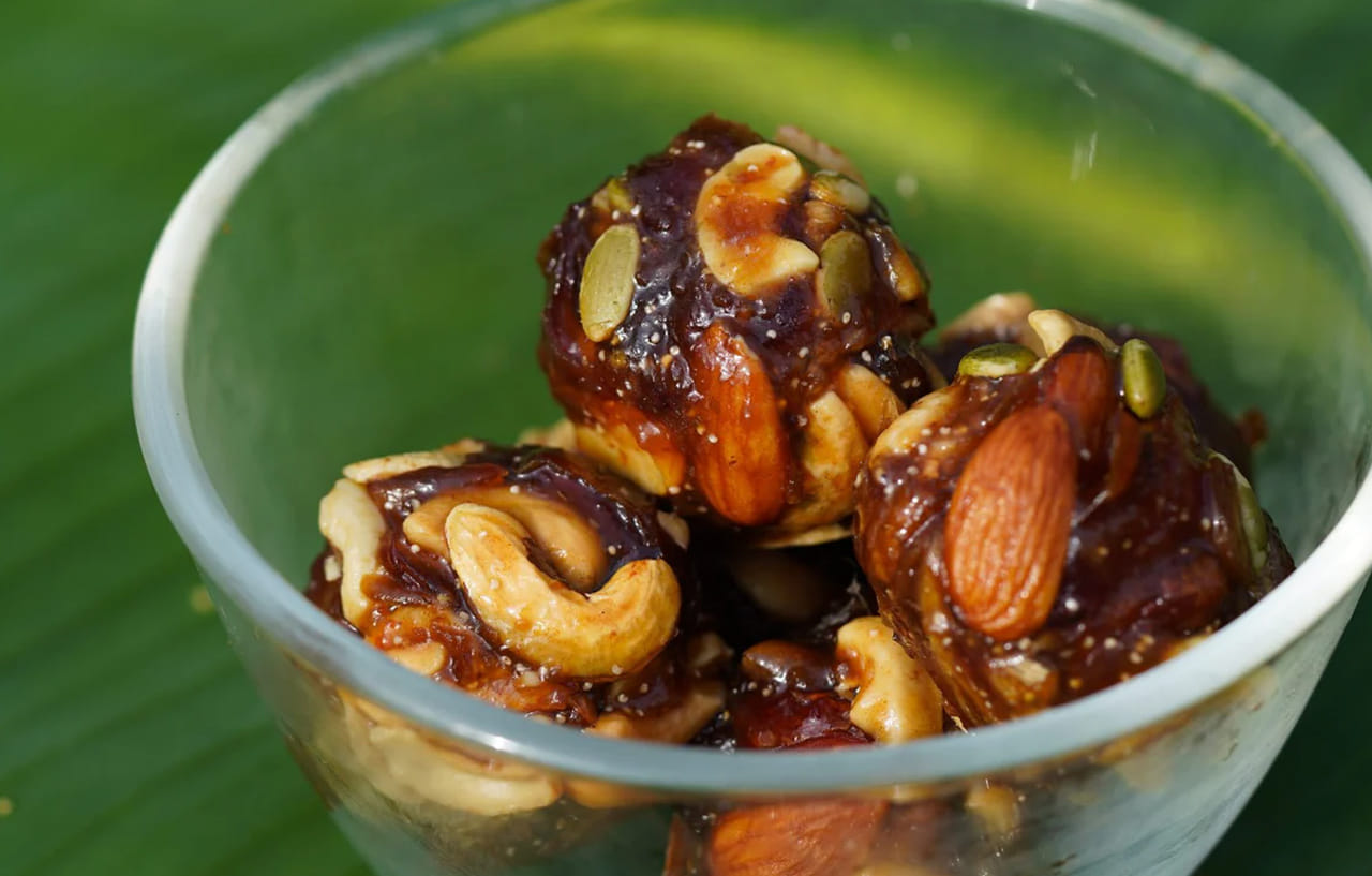 తర్వాత అదే పాన్‌లో వన్ టీ స్పూన్ నెయ్యి వేసి, దానిలో ఖర్జూర పేస్ట్ వేసి వేయించుకోవాలి. పేస్ట్ ముద్దగా అయ్యే వరకు వేయించుకోవాలి. తర్వాత స్టవ్ ఆఫ్ చేసి, ఈ మిశ్రమంలో డ్రై ఫ్రూట్ ముక్కలు,గసగసాలు, ఎండు కొబ్బరి తురుము, యాలకుల పొడి వేసి కలుపుకోవాలి. మొత్తం కలిసేలా కలుపుకోవాలి.