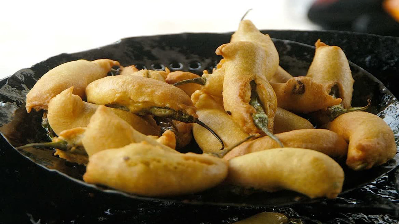 తర్వాత స్టవ్ ఆన్ చేసి, కడాయి పెట్టాలి. అందులో బజ్జీలు వేయించడానికి సరిపడ నూనె వేసి, మిర్చీలను శనగ పిండి మిశ్రమంలో నుంచి తీస్తూ నూనెలో వేసి వేయించుకోవాలి. అవి బంగారు రంగులో వచ్చే వరకు వేయిస్తూ ఉండాలి.