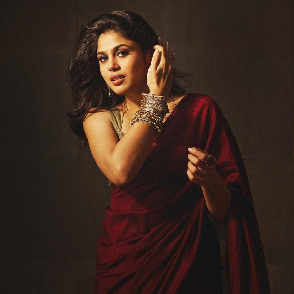 తాజాగా మెరూన్ కలర్ చీరకట్టులో చేతిలో గులాబీ పట్టుకుని ముసి ముసి నవ్వులతో ఫాలోవర్స్ హృదయాలను దోచుకుంటుంది. బ్లూ అండ్ ఆరెంజ్ కాంబోలో ఉన్న ప్లెయిన్ శారీలో కాటుక కళ్లతో మరింత అందంగా కనిపిస్తుంది ఈ అమ్మడు. 