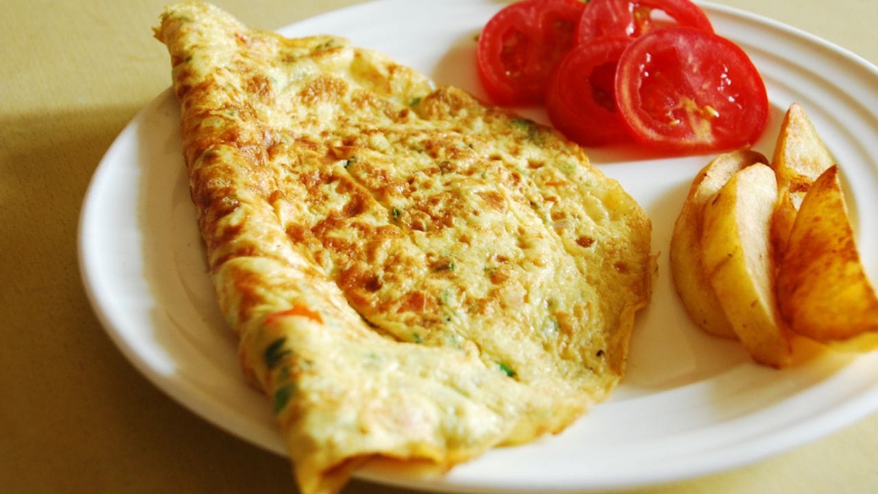 తయారీ విధానం: ఈ ఆమ్లెట్ ప్రిపేర్ చేయడానికి మీకు పెద్దగా టైం కూడా పట్టదు. ఇందుకోసం మీరు ముందుగా స్టవ్ వెలిగించి వెడల్పాటి పాన్ వేడి చేసి, అందులో రెండు టేబుల్ స్పూన్ల నూనె పోసి, నూనె వేడి అయిన తర్వాత, మీరు ముందుగానే తరిగిన ఉల్లిపాయలను సన్నగా తరిగిన ముక్కలుగా చేసి వేయించాలి. ఉల్లిపాయలు పచ్చి వాసన వచ్చి బంగారు రంగులోకి మారే వరకు వేయించాలి. ఉల్లిపాయలు వేగుతున్నప్పుడు, సన్నగా తరిగిన పచ్చిమిర్చి, కరివేపాకు, కొత్తిమీర వేసి కలపాలి. కరివేపాకు, కొత్తిమీరను నూనెలో వేయించడం వల్ల ఆమ్లెట్ కు మంచి వాసన వస్తుంది.