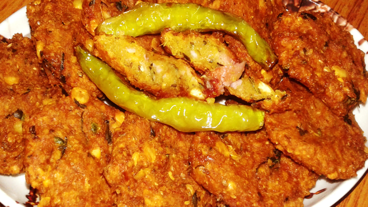 అలా ఆ పిండి మిశ్రమాన్ని ఒక గిన్నెలోకి తీసుకుని దానిలో కట్ చేసిన ఉల్లిపాయలు ముక్కలు వేసి కొద్దిగా కొత్తిమీర, కరివేపాకు వేసి చేతితో కలుపుకోవాలి.