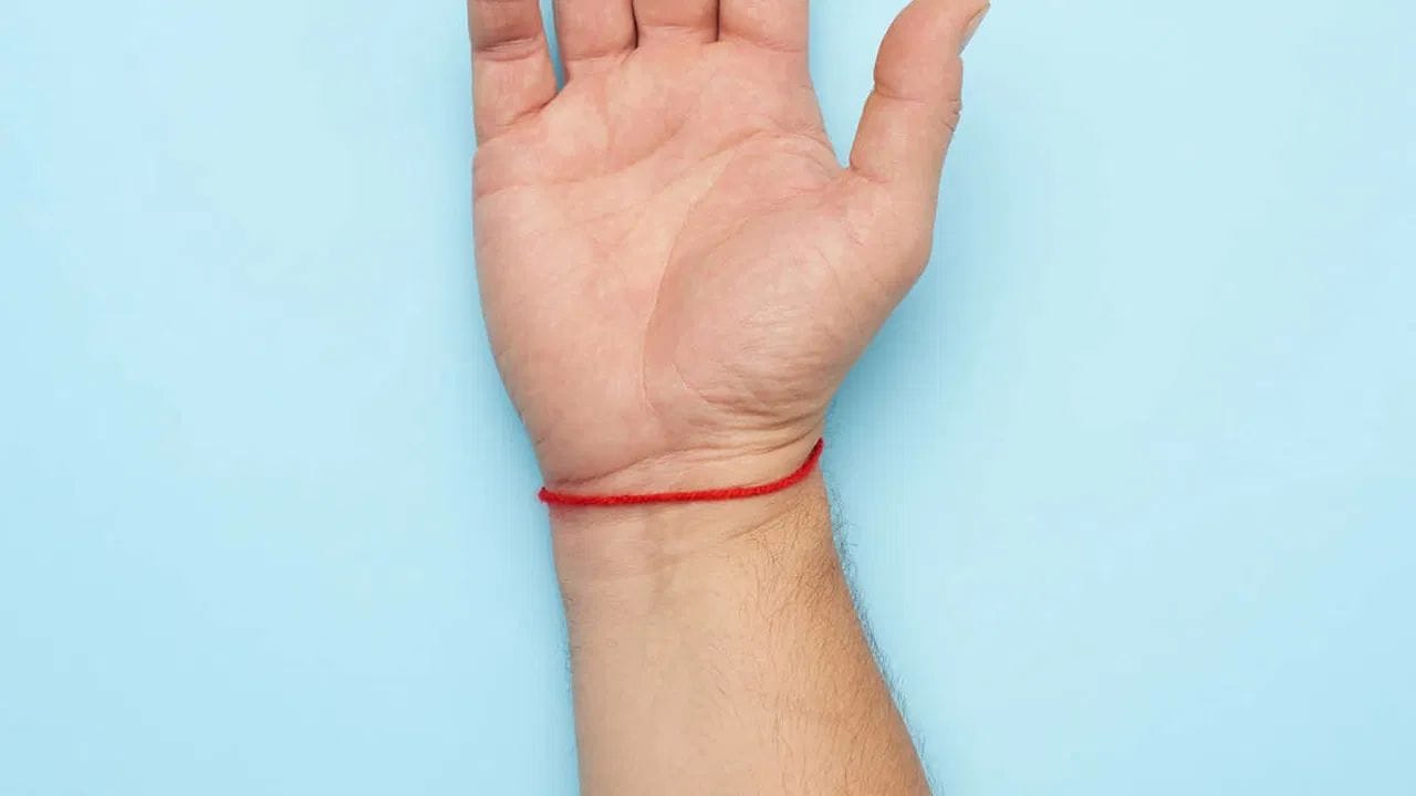 మత విశ్వాసాల ప్రకారం, చేతికి ఎర్ర దారం కట్టుకోవడం వల్ల మనపై లక్ష్మీదేవి కటాక్షం ఉంటుంది. దీనివల్ల హనుమంతుని ఆశీస్సులు కూడా లభిస్తాయని అంటారు. కుజ గ్రహం ఎరుపు రంగులో ఉంటుంది. అందువల్ల, ఎర్ర దారం కట్టుకోవడం జాతకంలో కుజ స్థానాన్ని బలపరుస్తుంది. దీనివల్ల ఆర్థిక ప్రయోజనాలు కూడా కలుగుతాయని అంటారు.        