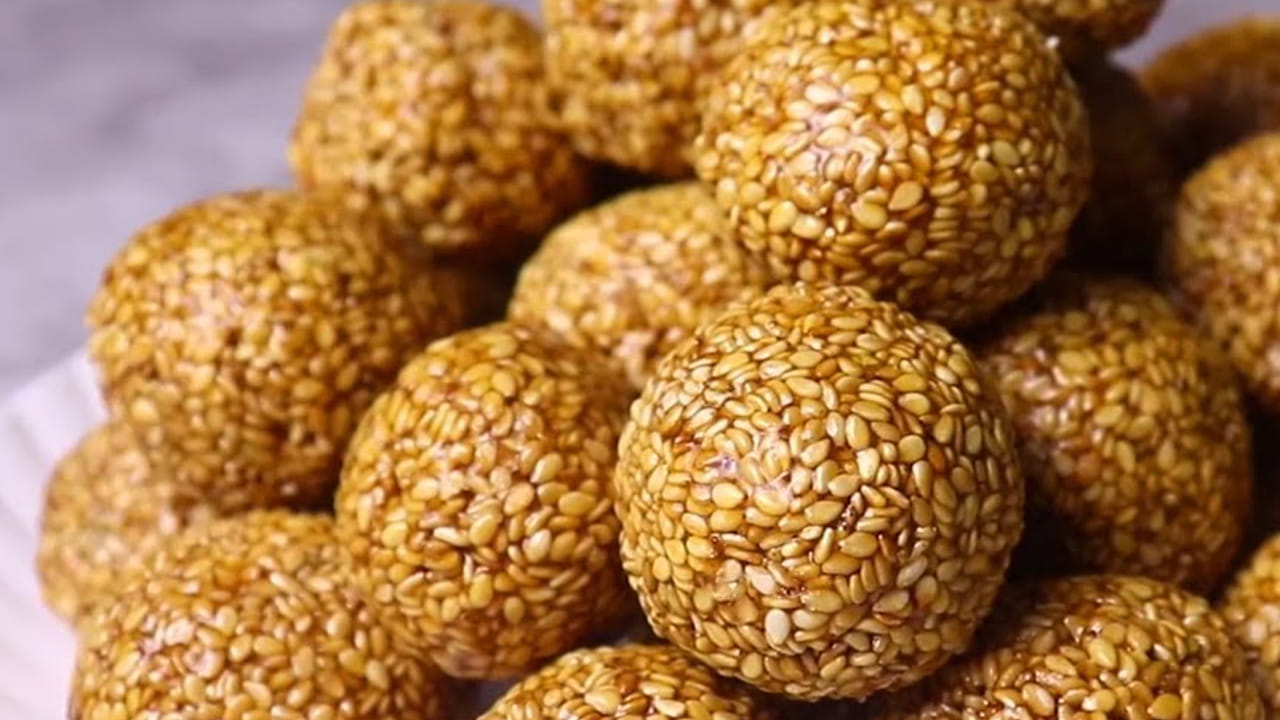 పల్లీ నువ్వుల లడ్డు తయారీ విధానం ముందుగా పల్లీలు వేయించుకోవాలి : గ్యాస్ వెలిగించి పాన్‌లో పల్లీలు వేసి మీడియం మంటపై వేయించుకోవాలి. ఈ మిశ్రమం చల్లారిన  తర్వాత పొడి లాగా దంచుకోవాలి. 
