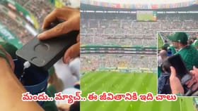 ఫుట్ బాల్ స్టేడియంలో కూర్చుని ఫోన్‌తో మందు తాగిన కిలాడీ