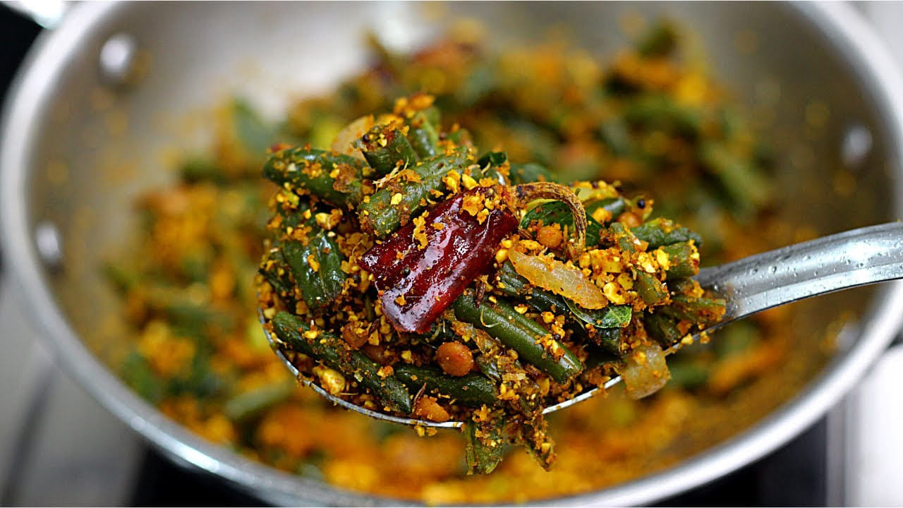 చల్లారిన తర్వాత అందులో ఎండుకొబ్బరి ముక్కలు, ఒక టీస్పూన్ కారం వేసి కాస్త బరకగా మిక్సీ పట్టాలి. ఆ తర్వాత 10 వెల్లుల్లి రెబ్బలను కూడా వేసి మరోసారి పల్స్ మోడ్లో కచ్చాపచ్చాగా గ్రైండ్ చేసి పక్కన పెట్టుకోవాలి.బీన్స్ ఫ్రై చేసే విధానం: పాన్లో ఒక టేబుల్ స్పూన్ నూనె వేసి వేడిచేయాలి. నూనె కాగిన తర్వాత తాలింపు గింజలు వేసి చిటపటలాడనివ్వాలి. ఆపై ఒక ఎండుమిర్చి, కరివేపాకు వేసి వేయించాలి.