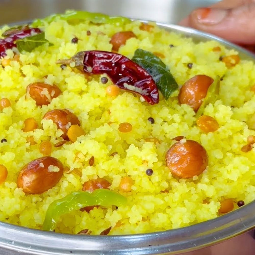 తయారీ విధానం: అడుగు మందంగా ఉన్న పాత్ర లేదా పాన్లో 4 కప్పుల నీళ్లు పోసి మూతపెట్టి మరిగించాలి. నీళ్లు మరుగుతున్నప్పుడు 2 టీస్పూన్ల ఉప్పు, అర టీస్పూన్ పసుపు, 2 టేబుల్ స్పూన్ల నూనె వేయాలి. ఇప్పుడు ఒకటిన్నర కప్పుల బియ్యపు రవ్వను వేస్తూ ఉండలు కట్టకుండా వెంటనే గరిటెతో బాగా కలపాలి. మీడియం మంటపై రెండు నిమిషాలు ఉడికించి, మిశ్రమం దగ్గరపడ్డాక మంటను పూర్తిగా లో ఫ్లేమ్లో పెట్టి మూతపెట్టాలి.