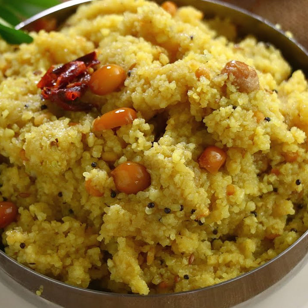 నీరంతా ఆవిరై రవ్వ మెత్తగా ఉడికేవరకు మధ్యమధ్యలో కలుపుతూ 7 నుండి 10 నిమిషాలు ఉడికించి స్టవ్ ఆఫ్ చేయాలి. ఈ రవ్వను పూర్తిగా చల్లారనివ్వాలి. చల్లారాక ముద్ద లేకుండా చక్కగా పొడిపొడిగా మారుతుంది. మరో పాన్లో 4 టేబుల్ స్పూన్ల నూనె వేడిచేసి మొదట పల్లీలు వేసి సగం వేగనివ్వాలి.