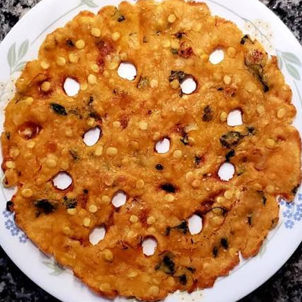 మంటను పూర్తిగా లో ఫ్లేమ్లో ఉంచి 7 నుండి 8 నిమిషాల పాటు కాల్చాలి. రొట్టె అంచులు ఎర్రగా మారి పాన్ నుండి విడివడినప్పుడు మూత తీసి చూసుకోవాలి. రొట్టెను తిరగేయాల్సిన పనిలేదు; లో ఫ్లేమ్పై నూనెలో వేగడం వల్ల కింద వైపు కరకరలాడుతూ, పైభాగం చక్కగా ఉడికిపోతుంది. అంతే, నోరూరించే కరకరలాడే గోదావరి స్టైల్ 'తపాలా రొట్టి' సిద్ధం! వేడివేడిగా తింటుంటే పల్లీలు, శనగపప్పు, ఉల్లిపాయల క్రంచీనెస్తో ప్రతి ముక్కా అద్భుతంగా ఉంటుంది