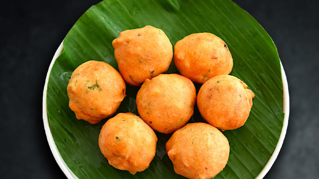 తర్వాత ఇప్పుడు మనం ఏ కప్పుతో పెరుగు తీసుకున్నామో అదే కప్పుతో ఒక కప్పు మైదా పిండిని తీసుకొని ఈ మిశ్రమంలో వేయాలి. తరువాత, కొద్దికొద్దిగా వేడినీళ్లను పోసుకుంటూ పిండిని బాగా కలుపుకోవాలి. మైసూర్ బోండా పిండి మరీ లూస్ గా ఉండకూడదు కాబట్టి, నీళ్లను ఒకేసారి కాకుండా కొద్దికొద్దిగా పోసుకుంటూ జాగ్రత్తగా కలపండి. వేడినీళ్లు ఉపయోగించడం వల్ల పిండి త్వరగా పులిసి, బోండాలు గుండ్రంగా వస్తాయి.
