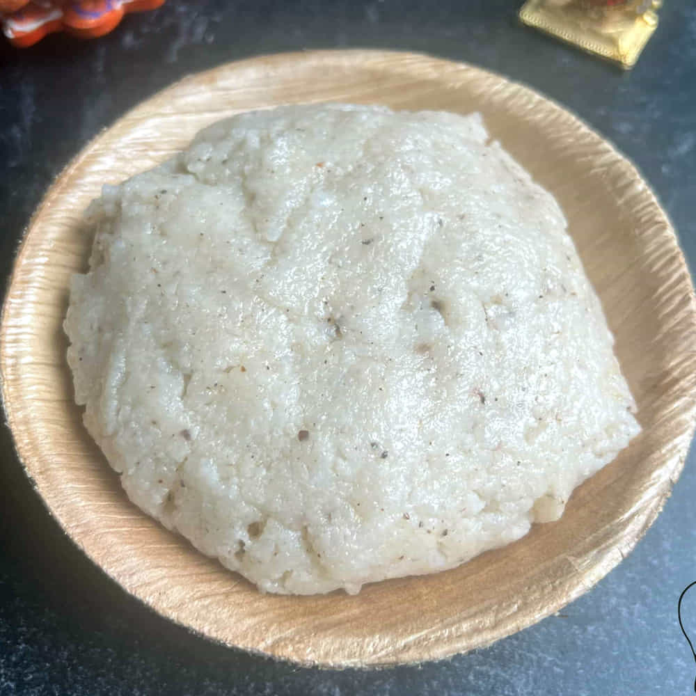 గంట నానిన బియ్యాన్ని కుక్కర్లో వేయాలి. బియ్యానికి నాలుగు రెట్లు (1 లీటర్) నీరు మరియు 20 గ్రాముల ఉప్పు వేసి కలపాలి. కుక్కర్ మూతపెట్టి మీడియం మంటపై 5 విజిల్స్ వచ్చే వరకు అన్నాన్ని చాలా మెత్తగా ఉడికించాలి. ఆవిరి పోయిన తర్వాత మూత తీసి గరిటెతో అన్నాన్ని మెదుపుతూ మెతుకు నలిగేలా కలపాలి. ఇప్పుడు కుక్కర్లో ఉడుకుతున్న ఈ ముద్ద అన్నంలోకి మరో అర లీటర్ మరిగే వేడి నీటిని పోసి గరిటెతో బాగా కలిపి పలుచగా, మృదువైన జారుడు ముద్దలా చేసుకోవాలి.