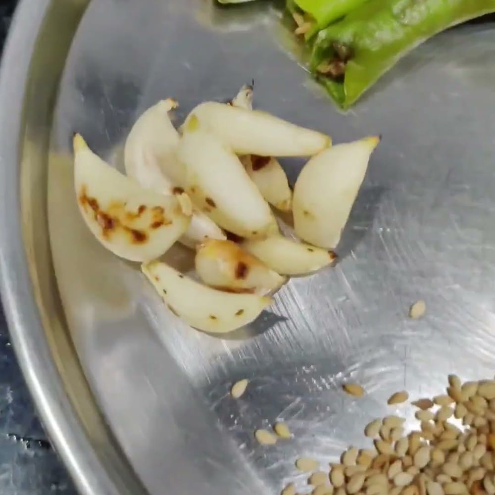 కావలసిన పదార్థాలు: 3 టేబుల్ స్పూన్ల తెల్ల నువ్వులు, 1 రెమ్మ కరివేపాకు, చిన్న నిమ్మకాయ సైజు అంత రసం తీసిన చింతపండు, 2 గ్లాసుల నీళ్లు, 1 టీస్పూన్ కారం పొడి, 1 టీస్పూన్ ధనియాల పొడి , అర టీస్పూన్ పసుపు, రుచికి సరిపడా ఉప్పు, 2 టేబుల్ స్పూన్ల బెల్లం తురుము, ఒకటిన్నర టేబుల్ స్పూన్ల వంట నూనె, అర టీస్పూన్ జీలకర్ర, 1 టీస్పూన్ పచ్చి శనగపప్పు, 1 టీస్పూన్ మినప్పప్పు, 7 నుండి 8 వెల్లుల్లి రెబ్బలు , 2 ఎండు మిరపకాయలు, 1 మీడియం సైజు ఉల్లిపాయ, 1 పెద్ద టమాటా
