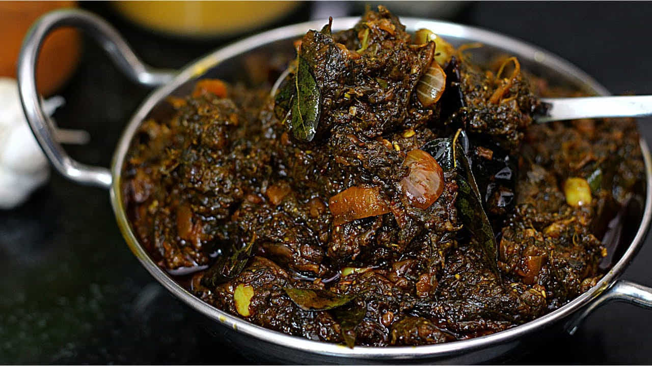 ఇప్పుడు అదే పాన్లో మరొక టేబుల్ స్పూన్ నూనె వేసి వేడెక్కిన తర్వాత, మూడు మధ్యస్థాయి టమాటాలను ముక్కలుగా కట్ చేసి వేసుకోవాలి. టమాటాలను ఒకసారి కలిపి, మూత పెట్టి మధ్యమధ్యలో కలుపుతూ మెత్తగా ఉడికించుకోవాలి. టమాటోలు బాగా ఉడికిన తర్వాత, ముందుగా శుభ్రం చేసి పెట్టుకున్న గోంగూర ఆకులను వేసుకోవాలి. గోంగూర ఆకులు టమాటోలో బాగా కలిసేలా కలుపుతూ, గోంగూర మెత్తబడేంత వరకు ఉడికించాలి.గోంగూర మెత్తబడిన తర్వాత, చిన్న ఉసిరికాయ అంత చింతపండు, పావు టీస్పూన్ పసుపు వేసి అంతా బాగా కలిసేలా కలుపుకోవాలి. మూతపెట్టి లో ఫ్లేమ్లో మధ్యమధ్యలో కలుపుతూ గోంగూర పచ్చిదనం పోయి, నూనె పైకి తేలే వరకు ఉడికించుకోవాలి. ఉడికిన తర్వాత స్టవ్ ఆఫ్ చేసి, ఈ మిశ్రమాన్ని పూర్తిగా చల్లారనివ్వాలి. గోంగూర మిశ్రమం చల్లారే లోపు, పచ్చడికి తాలింపు సిద్ధం చేసుకుందాం. ఒక పాన్లో రెండు టేబుల్ స్పూన్ల నూనె వేసి వేడి అయ్యాక, పావు టీస్పూన్ ఆవాలు, పావు టీస్పూన్ జీలకర్ర, ఒక టీస్పూన్ మినపగుళ్ళు, ఒక టీస్పూన్ పచ్చిశనగపప్పు వేసి వేయించుకోవాలి.